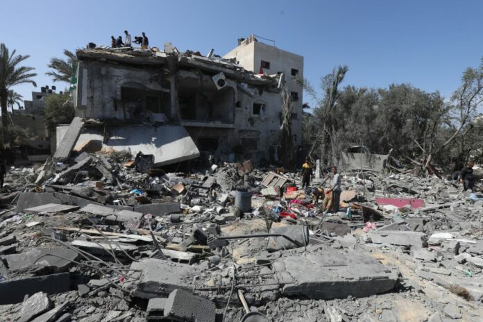 Striscia di Gaza: residenti palestinesi cercano di raccogliere i loro averi utilizzabili attorno alle macerie dopo un attacco israeliano